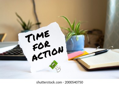 
Closeup Yellow Sticky Note paste it in a notebook setting an appointment. The words Time for action written on a white notebook to remind you an important appointment.
