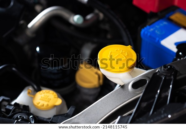 Closeup yellow windshield washer fluid reservoir
cap in engine room.