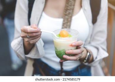 Closeup Young Adult Asian Foodie Woman Hand Eating Asia Dessert With Boba. People Traveling With Lifestyle Outdoor At China Town Street Food Market. Bangkok, Thailand