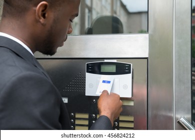 Close-up Of Young African Businessman Using Keycard To Open Door