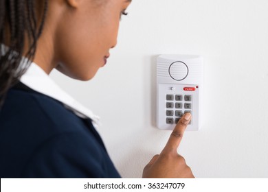 Close-up Of A Young African Businesswoman Pressing Button On Security System