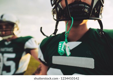 Closeup Of A Young American Football Player With His Mouthguard Hanging From His Helmet During An Afternoon Practice