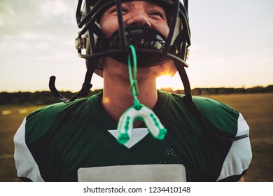 Closeup Of A Young American Football Player With His Mouthguard Hanging From His Helmet During A Team Practice Session