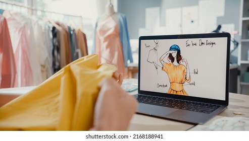 Close-up young Asia lady dressmaker with laptop on graphic sketch photo use tape measure fabric compare sample create dress design new collection on desk in shop. Tailor startup business concept. - Powered by Shutterstock