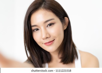 Close-up of young Asian beautiful woman taking selfie. Isolated white background.Beauty and Healthy Woman.
