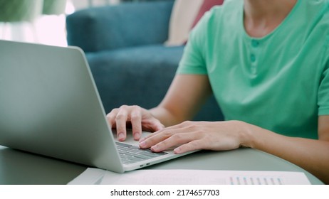 Close-up Of A Young Asian Man's Hand, Resting On His Laptop Computer, And The Other Hand Clutching His Head In Intense Stress With Hard Work.