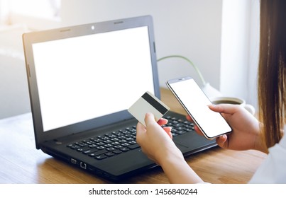 Closeup young asian woman working with laptop and using credit card to payment and shopping on line with smartphone