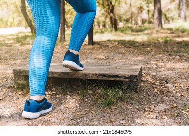 Close-up Of A Young Athlete's Legs From Behind, Doing Aerobic Exercise Outdoors. Sporty Woman Jumping. Health And Wellness Lifestyle.