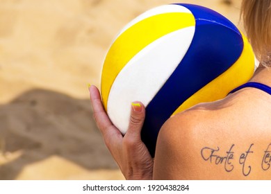 CLOSEUP A young athletic woman with a tattoo on her back prepares for a beach volleyball game. Female beach volleyball player. Russia, Lipetsk city, 2019.07.20 