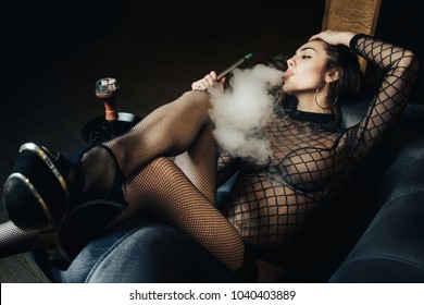 Close-up of young, beautiful girl Smoking hookah in the club. Sexy Smoking woman.