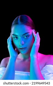 Closeup young beautiful woman and well  kept skin   sophisticated facial features isolated over dark background in purple neon light  Concept art  fashion  style  inspiration  emotions 