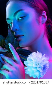 Closeup young beautiful woman and well  kept skin   sophisticated facial features isolated over dark background in purple neon light  Concept art  fashion  style  inspiration  emotions 