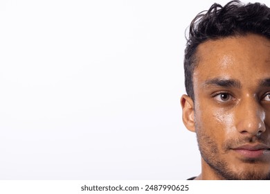 Close-up of a young biracial man, with copy space, on a white background. His expression suggests contemplation or concern, set against a neutral background. - Powered by Shutterstock