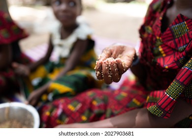 Closeup of a young black child's hand holding traditional African food; hunger concept