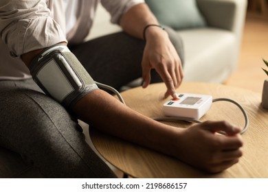 Closeup Of Young Black Man Checking Blood Pressure, Using Modern Tonometer At Home. Unrecognizable African American Male Having Hypertension, Feeling Unwell, Cropped View