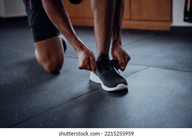 Close-up Of Young Black Man Tying Shoelace Of Sports Shoe At The Gym