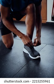 Close-up Of Young Black Man Tying Shoelace Of Shoe At The Gym