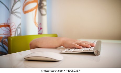 Closeup Of Young Boy's Hand Touching Computer Keypad While Being Under The Table