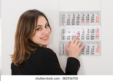 Close-up Of Young Businesswoman Placing Red Mark On Calendar Date