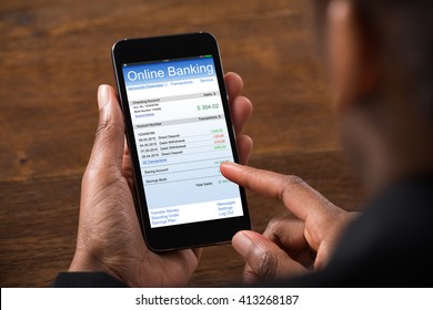 Close-up Of Young Businesswoman Using Online Banking On Mobile Phone In Office