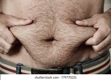 Closeup Of A Young Caucasian Man Grabbing The Fat Of His Hairy Stomach