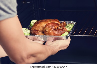 Closeup Of A Young Caucasian Man Preparing An Appetizing Roast Turkey In The Oven