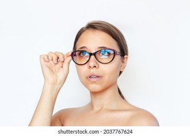 Close-up Of A Young Caucasian Woman With Red And Black Female Glasses For Working At A Computer With A Blue Filter Lenses Isolated On A White Background. Anti Blue Light And Rays. Eye Protection