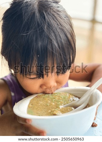 Similar – Image, Stock Photo Young child savoring a blue lollipop enthusiastically