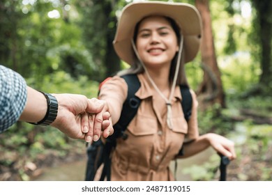 Close-up of young couple holding hands on a hiking trip in the forest, selective focus - Powered by Shutterstock
