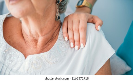 Close-up of young elegant woman's hand on senior lady's shoulder.  Sign of caring for seniors. Helping hands. Care for the elderly concept. Elderly woman having private medical care  - Powered by Shutterstock