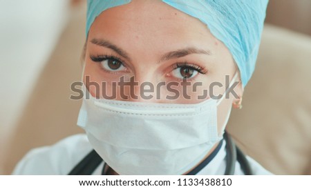 Close-up of young female doctor with a mask on face