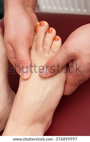 Close-up of young female feet receiving a sole massage as relaxation and wellness concept