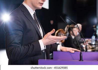 Close-up Of A Young Formally-dressed Man Giving A Public Speech In A Conference Room