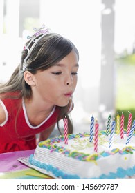 Closeup Of A Young Girl Blowing Out Birthday Candles