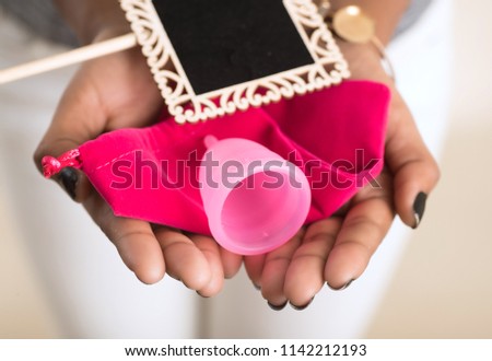 Close-up of young girl hands holding menstrual cup, Gynaecology concept, Showing thumbs up approving the use of the menstrual cup