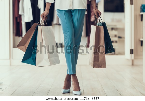 店で買い物袋を持つ若い女の子の接写 モール内のブティックで買い物用紙袋を持つ黒い女の子の接写 アフリカ人女性の服屋 女性の買い物のコンセプト の写真素材 今すぐ編集