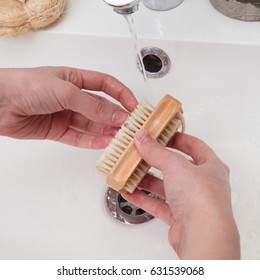 closeup of young hands washing her finger nails, cleaning with a wooden brush and tap water and soap for hygiene and cleanliness in home bathroom