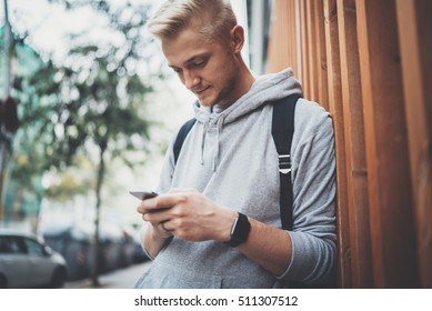 Close-up Of Young Hipster Man Using Smartphone Device Outside, Smiling Caucasian Guy Using An App On His Cellphone To Play A Augmented Reality Mobile Game In The Park, Social Networking Concept