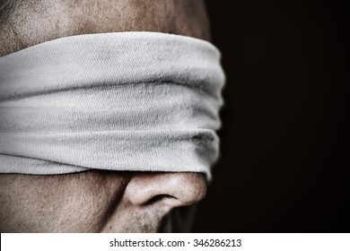 closeup of a young man with a blindfold in his eyes, as a symbol of oppression or repression, with a dramatic effect