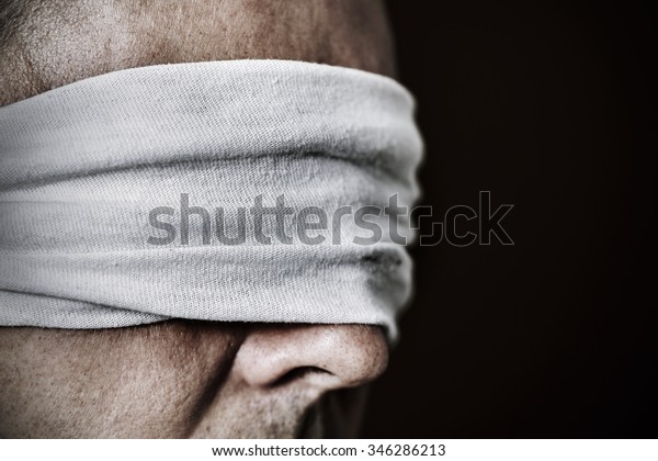 closeup
of a young man with a blindfold in his eyes, as a symbol of
oppression or repression, with a dramatic
effect