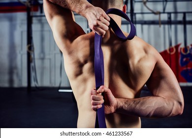 Closeup Of  Young Man During Mobility Exercise Stretching Arms With Rubber Band