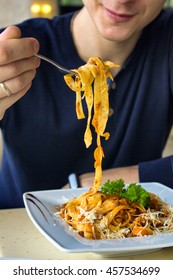 Closeup Of Young Man Eating Pasta In The Cafe