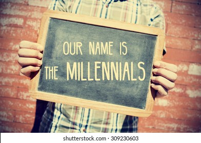 closeup of a young man holding a chalkboard with text our name is the millennials in front of a brick wall, slight vignette added 