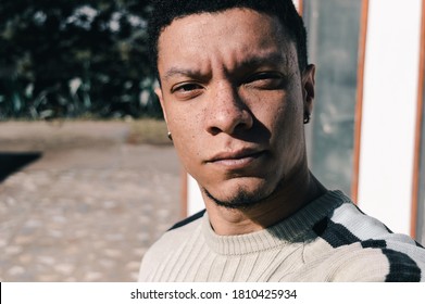 Close-up Of Young Man With Serious Look And Freckles On His Face