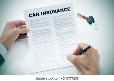 Closeup Of A Young Man Signing A Car Insurance Policy