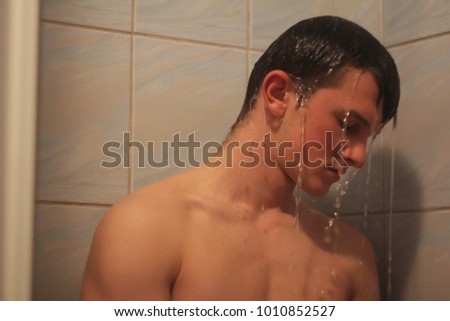Close-up of a young man taking a shower,sad young man 