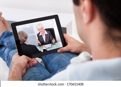 Close-up Of Young Man Watching Movie On Tablet Pc