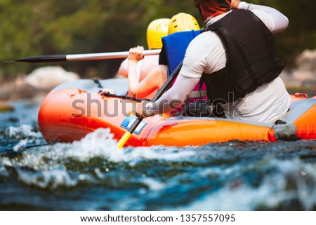 Close-up of young people rafting on the river turbulent flow. Extreme and enjoyment sport.