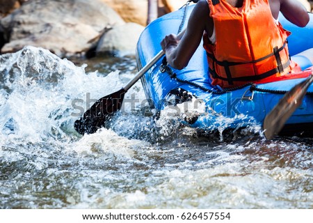 Close-up of young person rafting on the river, extreme and fun sport at tourist attraction
