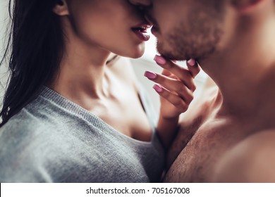 Close-up of young romantic couple is kissing and enjoying the company of each other at home.